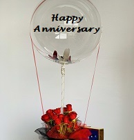 Happy Anniversary printed balloon bouquet decorated with 12 red roses basket